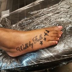 a person with a tattoo on their foot that says walk by faith