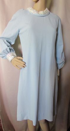 "LAST CALL! 50% OFF! Offered is an example of evening wear from the 1960's, early 1970's. It is actually a little demure, but combine it with a beehive hairdo and one can be quite the vamp. The robin egg blue polyester crepe is contrasted with iridescent white sequins in a 2 1/2\" band at the rolled neckline and the sleeve cuffs. The design is long sleeved and A-Line. The cuffs close with snaps and there is a 24\" hidden nylon zipper at the back. Before we give the measurements, we want to menti Blue Long Sleeve Vintage Party Dress, Elegant Blue Vintage Dress For Evening, Elegant Blue Vintage Evening Dress, Elegant Blue Vintage Dress For Party, Elegant Blue Vintage Party Dress, Formal Long Sleeve Blue Vintage Dress, Formal Blue Long Sleeve Vintage Dress, Spring Evening Vintage Blue Dress, Vintage Blue Elegant Dresses For Formal Occasions