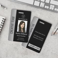 two id cards sitting on top of a desk next to a keyboard and pencils