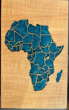 a wooden plaque with the shape of africa painted on it's side in blue