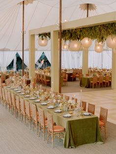 a large tent with tables and chairs set up for a formal dinner or banquet event