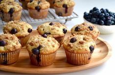 blueberry muffins are on a wooden plate