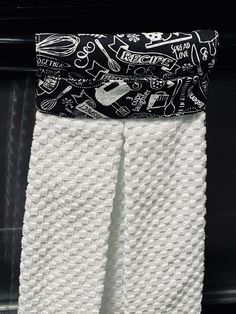 two white towels are hanging on a towel rack in front of a black fire place