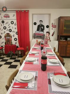 a long table with red and white checkered cloths, place settings and plates on it