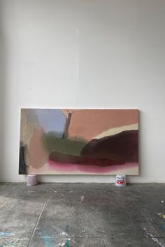 an abstract painting is on the wall next to a paint can