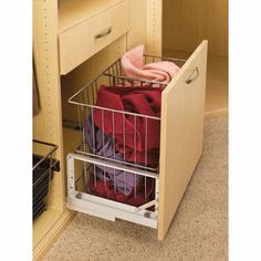 a metal basket is in the bottom drawer of a cabinet that has folded towels and blankets on it