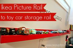 toy cars are lined up on a red shelf in front of a white wall with the words ikea picture rail to toy car storage rail