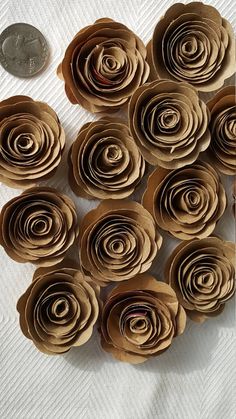 a bunch of rolled up paper flowers next to a penny