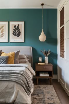 a bedroom with teal walls and artwork on the wall above the bed, along with two nightstands