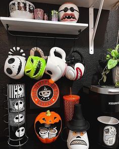 there are many halloween themed items on the shelf in this room, including cups and saucers