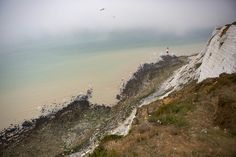 a person standing on top of a cliff near the ocean