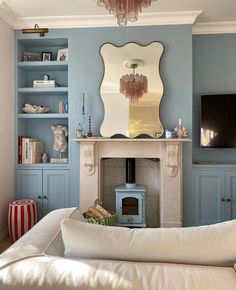 a living room filled with furniture and a fire place in front of a tv mounted on a wall