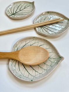 three leaf shaped plates with wooden spoons on them