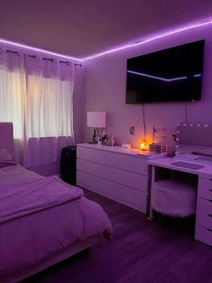 a bedroom with purple lighting in the ceiling and white bedding on the dressers