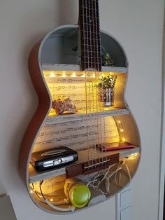 a guitar shaped shelf is lit up with lights