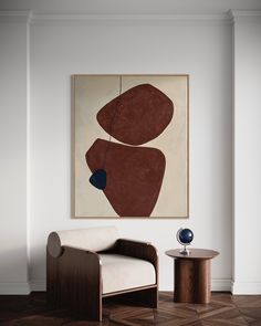 an abstract painting hangs on the wall next to a chair and table in a living room