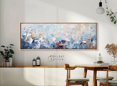 a painting hanging on the wall above a dining room table