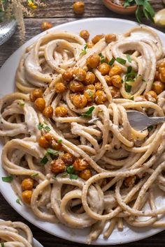 a white plate topped with pasta and chickpeas