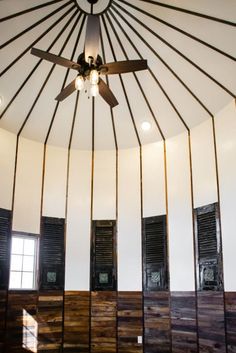 a ceiling fan is hanging from the ceiling in a room with wood paneling and shutters