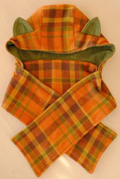 an orange and green checkered scarf laying on top of a white surface