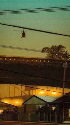 an overhead view of a building at night with traffic lights and power lines in the foreground