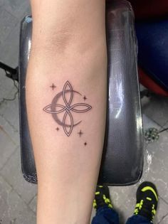 a woman's arm with a tattoo on it that has an image of a star in the center