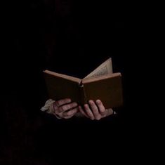 a person reading a book in the dark