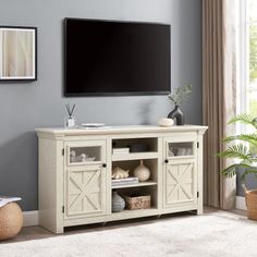 a flat screen tv mounted to the side of a white wooden entertainment center in a living room