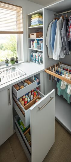 an organized kitchen with white cabinets and open drawers in the cupboards that are filled with items