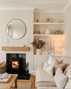 a living room filled with furniture and a fire place in front of a mirror on the wall