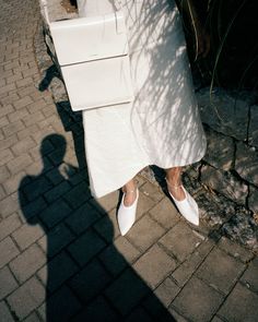 the shadow of a person in white shoes