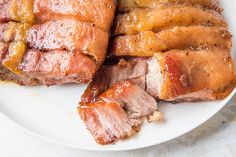 some meat on a white plate with sauce and seasoning around the edges, ready to be eaten