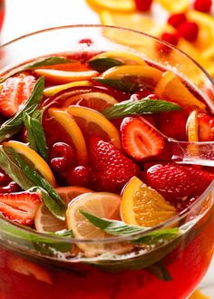 a glass filled with fruit and garnish on top of a table