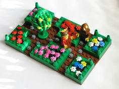 a lego garden is shown with flowers and trees