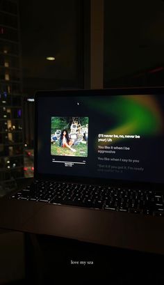 an open laptop computer sitting on top of a desk in front of a large window