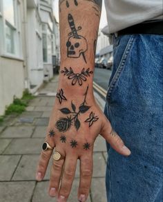 a person with a tattoo on their arm and hand is holding something in the other hand