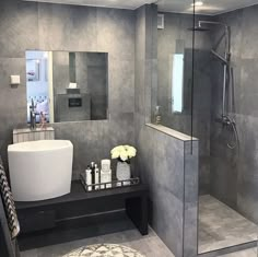 a bathroom with a stand up shower, sink and mirror on the wall next to it