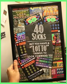 a person holding up a framed poster with the words 40 sucks but you have 4 lotto