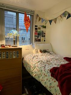 a bedroom with a bed, dresser and window