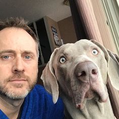 a man and his dog are posing for the camera with their eyes wide open,