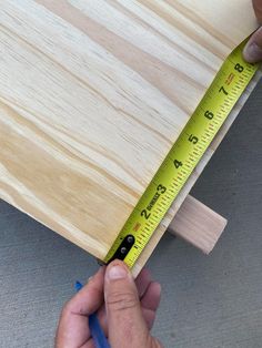 a person measuring the width of a piece of wood