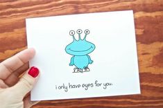 a person holding up a card with an image of a frog on it