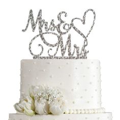 a white wedding cake with silver mr and mrs topper