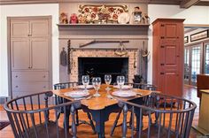 a dining room table with chairs around it and a fire place in the back ground