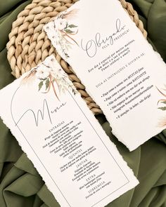 two wedding programs are sitting on top of a green cloth next to a woven basket