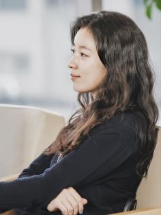 a woman sitting in a chair with her arms crossed