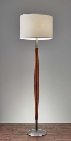 a lamp that is sitting on top of a wooden table next to a white shade