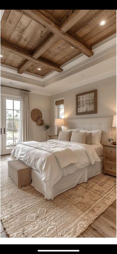 a large white bed sitting inside of a bedroom on top of a carpeted floor