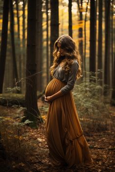 a pregnant woman is standing in the woods