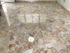 an empty kitchen with marble flooring and white appliances in the backgroung